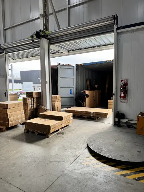 Descarga en curso: un operario adentro del contenedor y los pallets ya armados en el muelle
